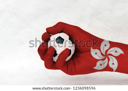 Mini ball of football in Hong kong flag painted hand on white background. Concept of sport or the game in handle or minor matter. the red and white five petal Bauhinia blakeana flower.