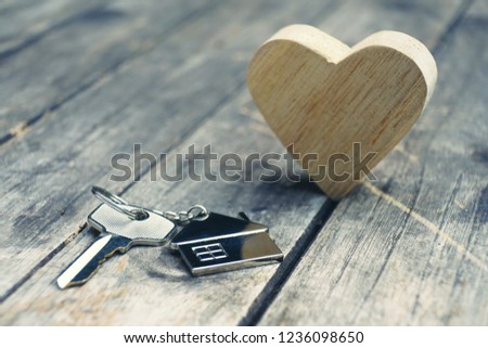 Home key with house keychain and wooden heart mock up on vintage wood background, home sweet home concept, copy space