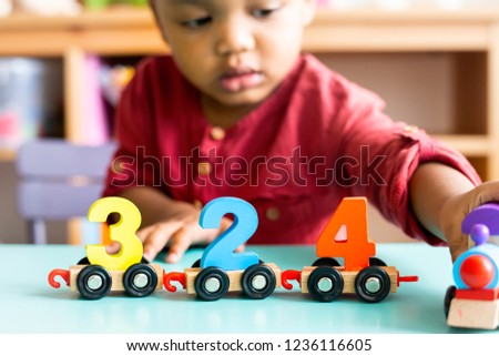 Little boy playing mathematics wooden toy at nursery Royalty-Free Stock Photo #1236116605