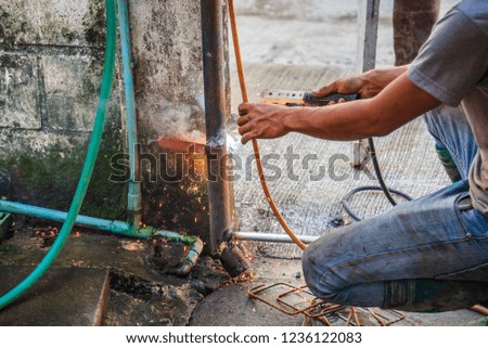 image of welder man fix the door with weld machine to see fire spark on steel rod.