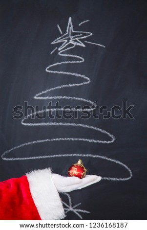 Santa Claus hand holding christmas ball. new year and christmas greeting card