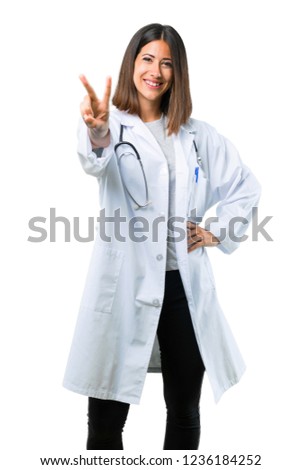 Doctor woman with stethoscope smiling and showing victory sign on isolated white background