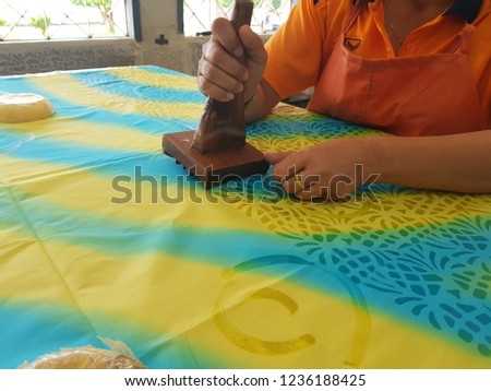 A native cloth printing company of producing colored designs on textiles by dyeing them, having first applied wax to the parts to be left undyed called batik and cloth pattern mold