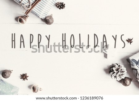 Happy Holidays text on modern christmas flat lay with ornaments and gift boxes, top view with space for text. Season's greetings card. Merry Christmas and Happy new year