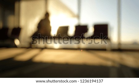 Blur silhouettes of bench in interior in airport lounge with man in the morning 