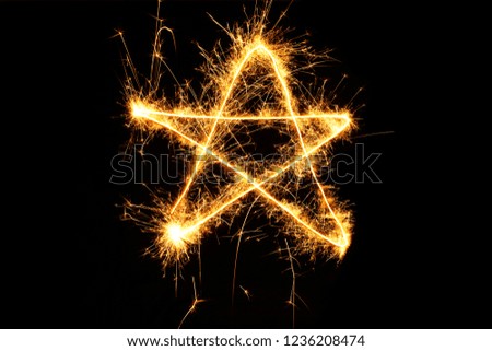 Christmas star. Pointed star drawing sparkling sparklers isolated on black background. Element for design. Beautiful Glowing overlay template for holiday greeting card.