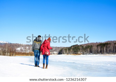 Couple walking on a frozen lake surface