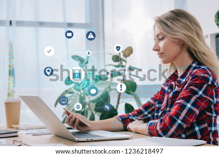 side view of businesswoman using smartphone at workplace in office, cyber security concept
