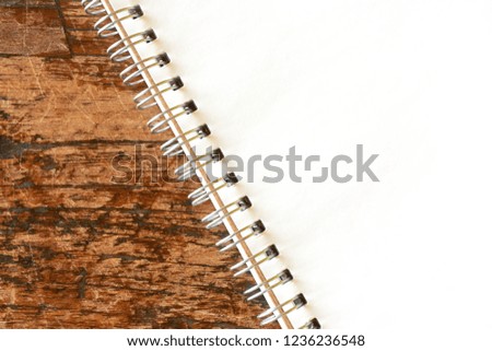 Top view image of blank open notebook page with spiral ring on dark wooden background with copy space. For use as mock up                      