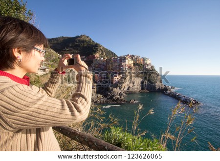 female tourist taking picture of Manarola village