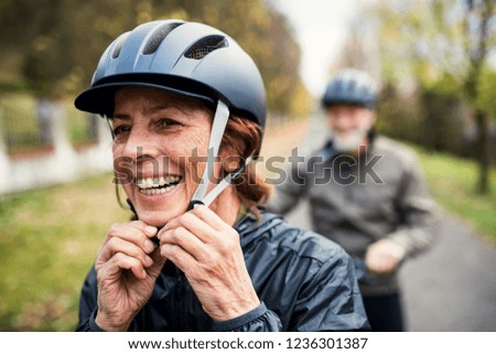 Active senior couple with electrobikes standing outdoors on a road in nature. Royalty-Free Stock Photo #1236301387