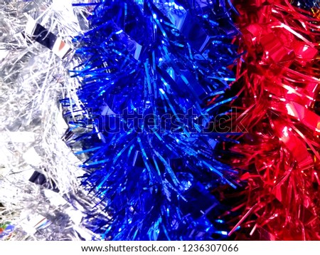 Red, blue and white new year tinsel decoration background. Close up photography