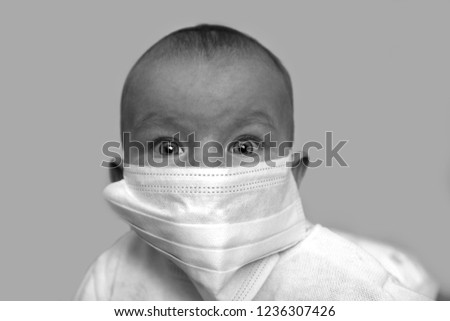 scared baby in a medical mask Royalty-Free Stock Photo #1236307426