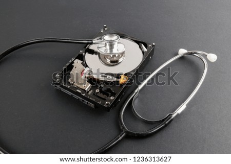 RECOVERY AND REPAIR TECHNOLOGY CONCEPT: Hard Disk Drive (HDD) with stethoscope isolated on a black background