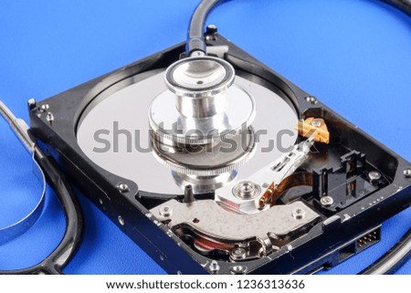 RECOVERY AND REPAIR TECHNOLOGY CONCEPT: Hard Disk Drive (HDD) with stethoscope isolated on a blue background