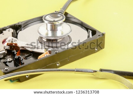 RECOVERY AND REPAIR TECHNOLOGY CONCEPT: Hard Disk Drive (HDD) with stethoscope isolated on a yellow background