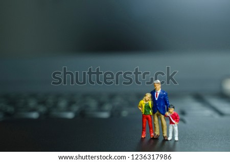 Property insurance and  Real estate concept.,miniature Dad and Kids standing on a laptop keyboard.
