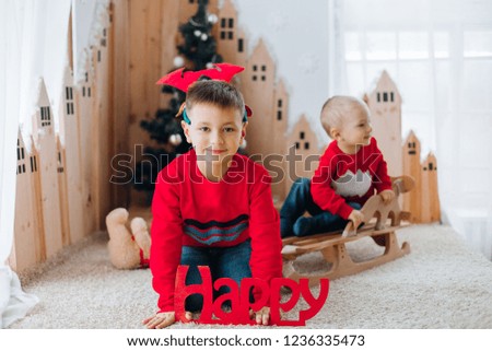 Cheerful cute childrens boys opening gifts near beautiful Christmas tree. New Year Celebration. Decorations