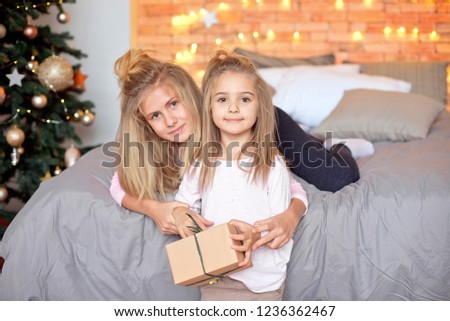 Merry Christmas and Happy Holidays. Cheerful cute children opening gifts. Kids having fun near tree in the morning. Loving family with presents in room. New Year