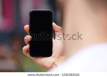 Man with smart phone on hand, blurred background.