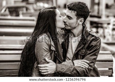 a young man gives a gift to a young girl in the cafe and they are kissing. Image in black and white color style