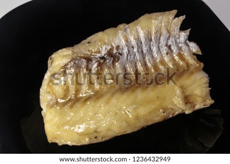 Boiled cod on a black dish. Dietary food. Delicatessen.