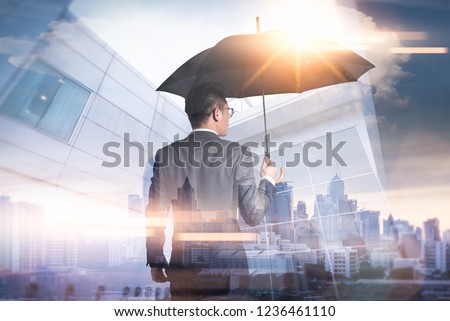 The double exposure image of the Businessmen are spreading umbrella during sunrise overlay with cityscape image. The concept of modern life, business, insurance and protection. Royalty-Free Stock Photo #1236461110
