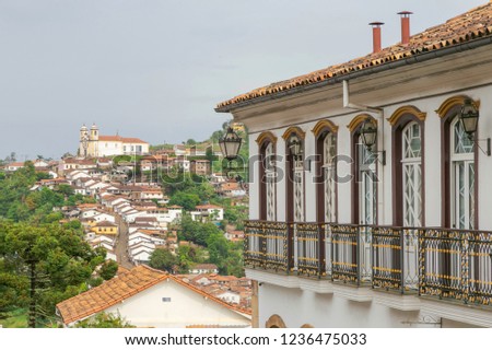 Colonial mansion in the historical center of the city of Ouro Preto, in the foreground, and Church of Santa Iphigênia in the background with houses down the hill
