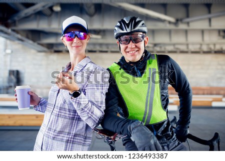 Photo of sporty woman and man with bicycle on blurred background