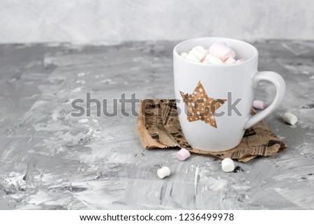 cute cup with marshmallows on a gray grunge concrete background