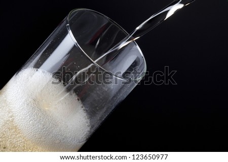 Close-up shot of champagne being poured in a flute.