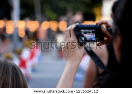 Blurred perspective image of people or traveler take a photo by DSLR camera on the twilight time with bokeh background.