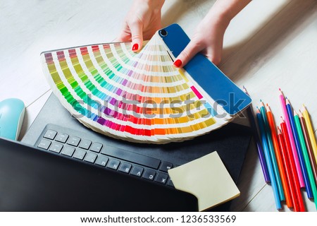 Woman designer chooses color from color palettes