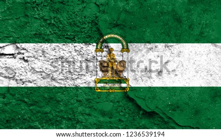 Flag of Andalusia close up painted on a cracked wall, concept of armed actions and conflicts in the world