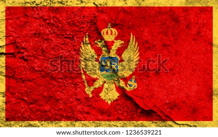 Flag of Montenegro close up painted on a cracked wall, concept of armed actions and conflicts in the world