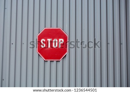stop sign on iron background near brick wall