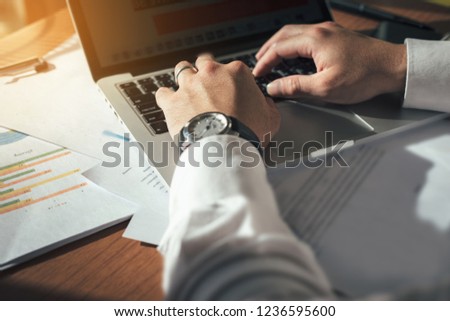 Businessman at workplace Think business investment plan.Contact Investor using cell phone,computer.make note of appointment information in the notebook.design creative work space 
