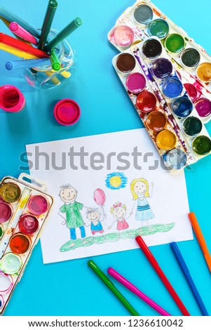 Children's drawing a happy family and artistic brushes and paints on a blue background, mother's day