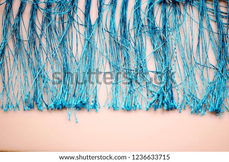 Fringe of threads on a pink background