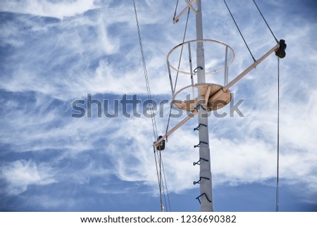 The mast of large wooden ship. Beautiful travel picture with masts and rigging of sailing ship against blue orange sky. Background for tourist advertising