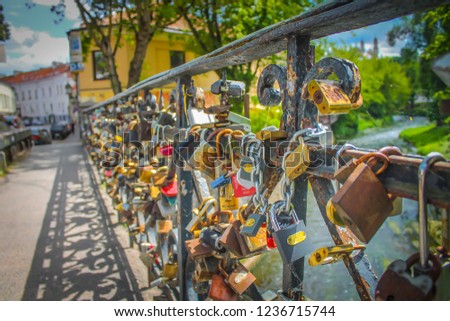 Bright and romantic love locks on the metal fence of the bridge