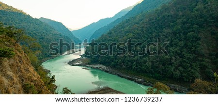 Spectacular view of the sacred Ganges river flowing through the green mountains of Rishikesh, Uttarakhand, India. Royalty-Free Stock Photo #1236739237