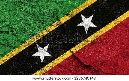 Flag of Saint Kitts and Nevis close up painted on a cracked wall, concept of armed actions and conflicts in the world