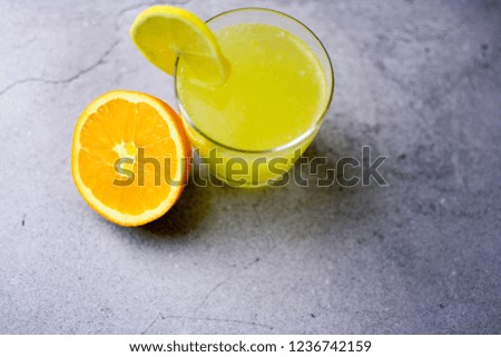 Lemon juice with lemon, orange and white sugar on a grey table. High angle view. selective focus, high contrast, authentic, retro. playful, funny.