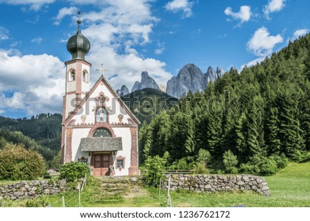 Romantic church built on colourful meadow in the Italian Dolomites.