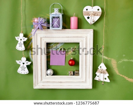Wooden vintage frame with decor on a green background painted pastel, congratulations on seasonal holidays, Christmas, New Year, Valentines Day. Home interior 
