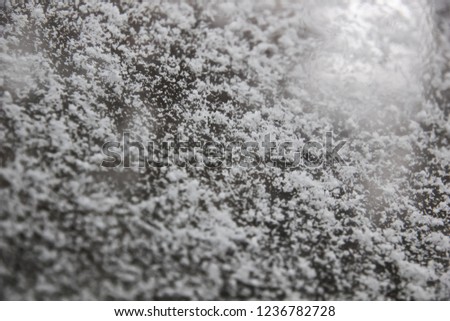 Background image of snow lying on a smooth surface. Auto glass and first bokeh snow