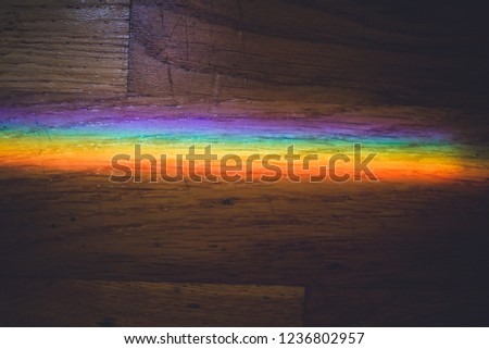 Close up macro photo of rainbow on wooden floor.