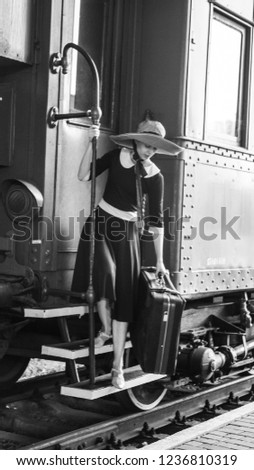 a young lady arrives in the city by train. retro photo. old style