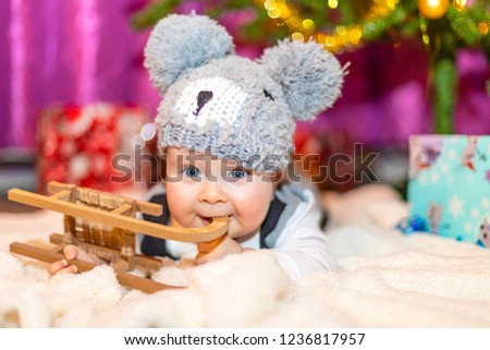 Christmas baby boy smiling near christmas tree